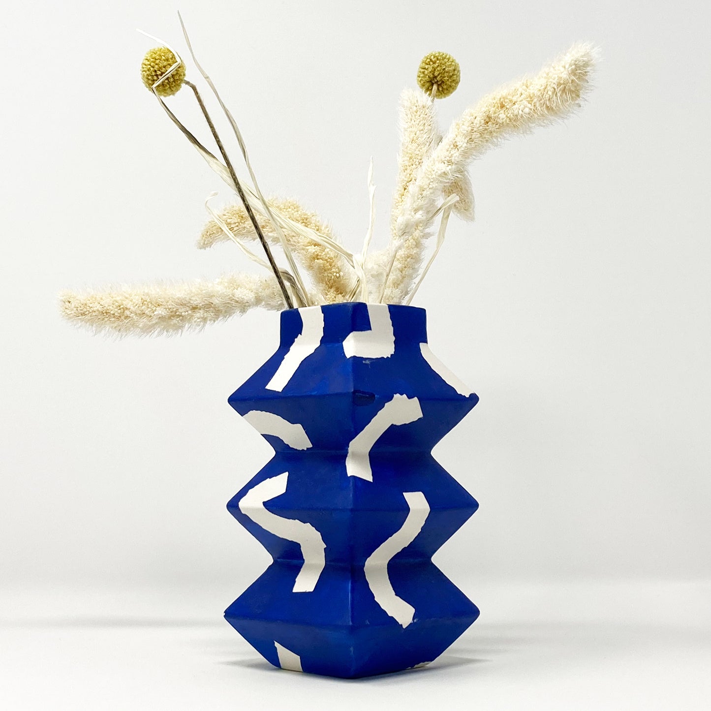 Colourbox Studio - Zigzag Vases - Blue, with flowers. Side View